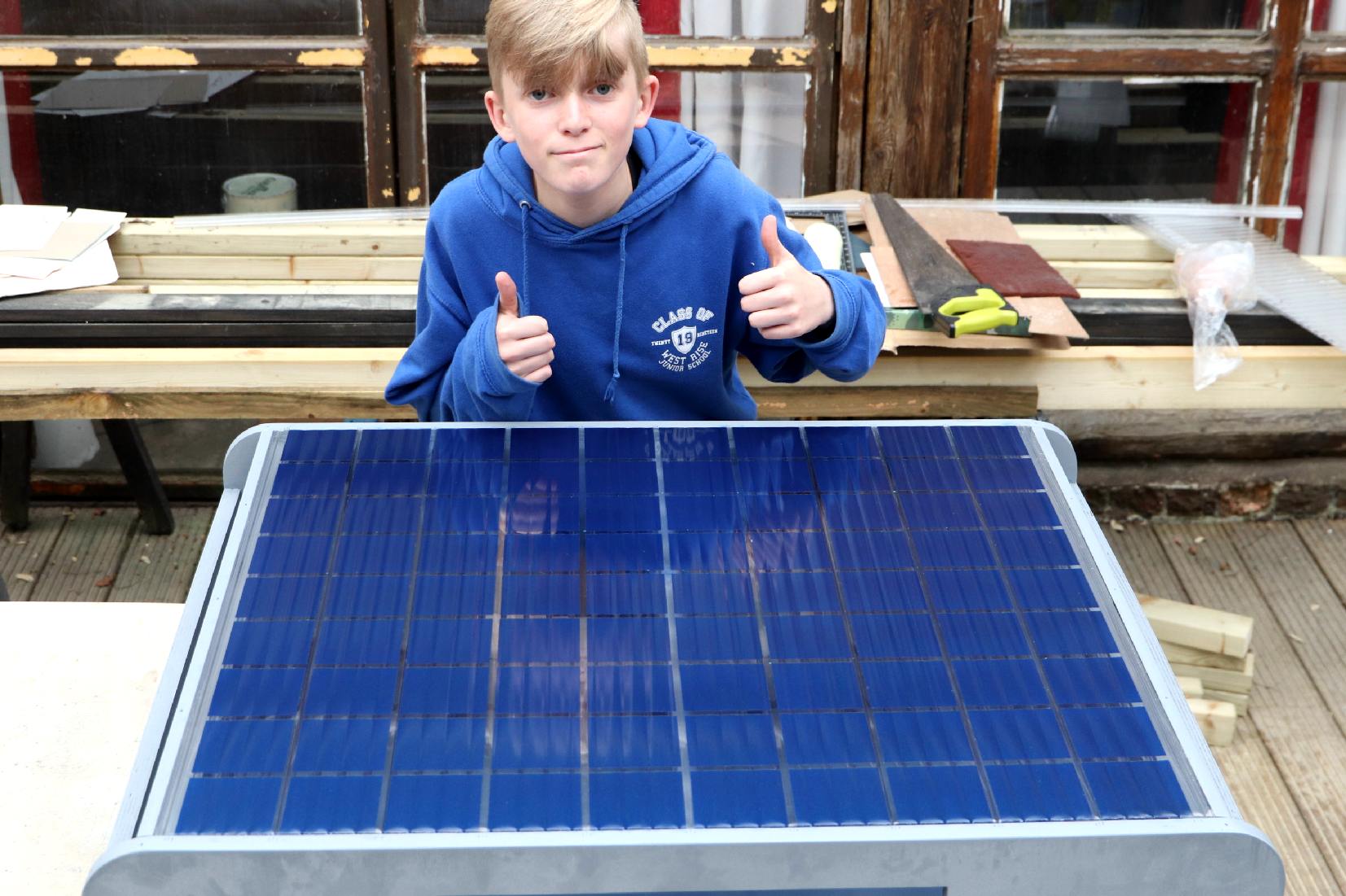 A young volunteer is helping to make the 1:20th scale model of a SmartNet EV service station