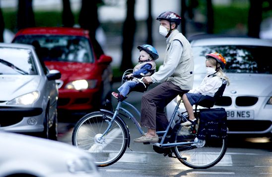 A cyclist wears a mask to help him breath in the city