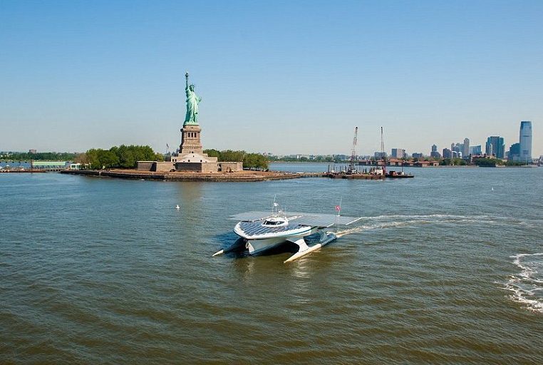 Autonomous solar boat, PlanetSolar, enters New York harbor, Statue of Liberty