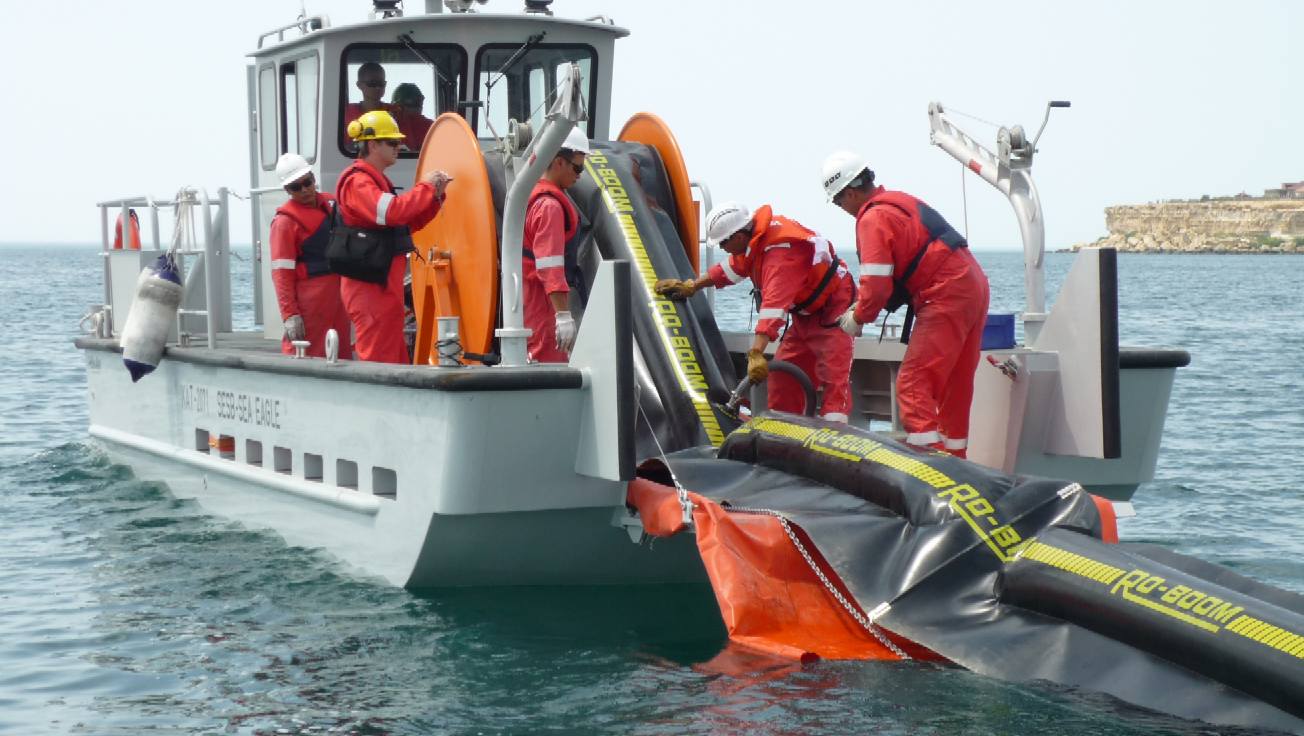 Oil spill response boat deploying booms